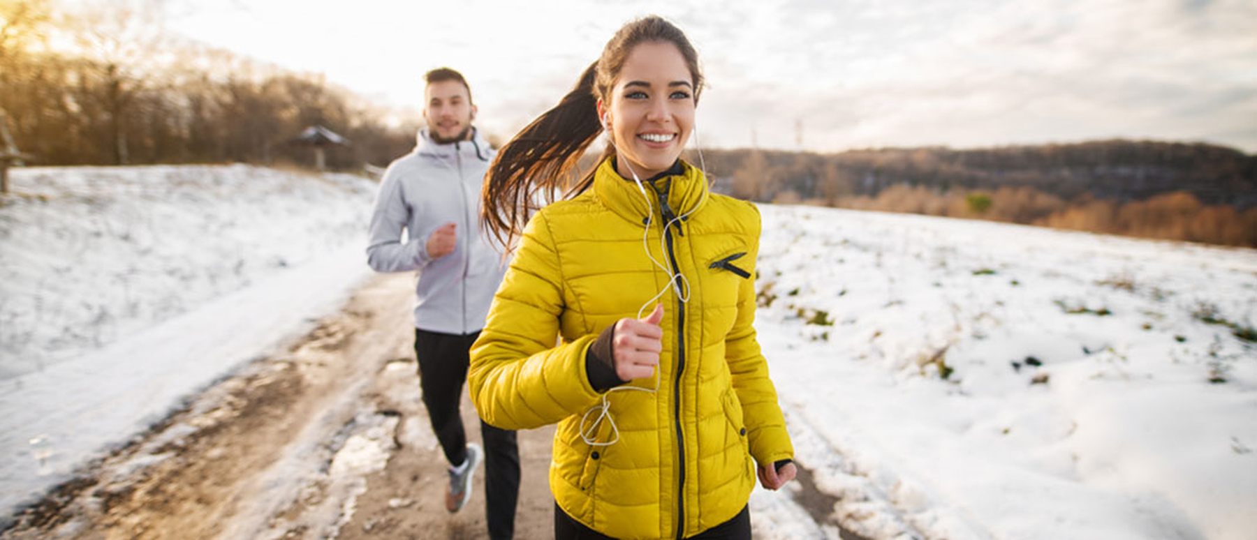 Young couple running on a trail in the snow