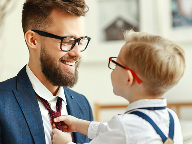Young boy straightening his dad's tie