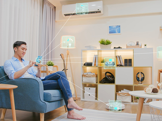 Asian man sitting with his device controlling his smart home