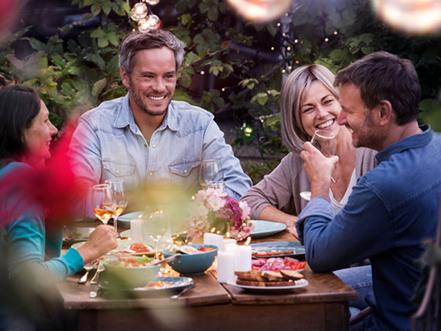 Happy people having dinner at a table outside